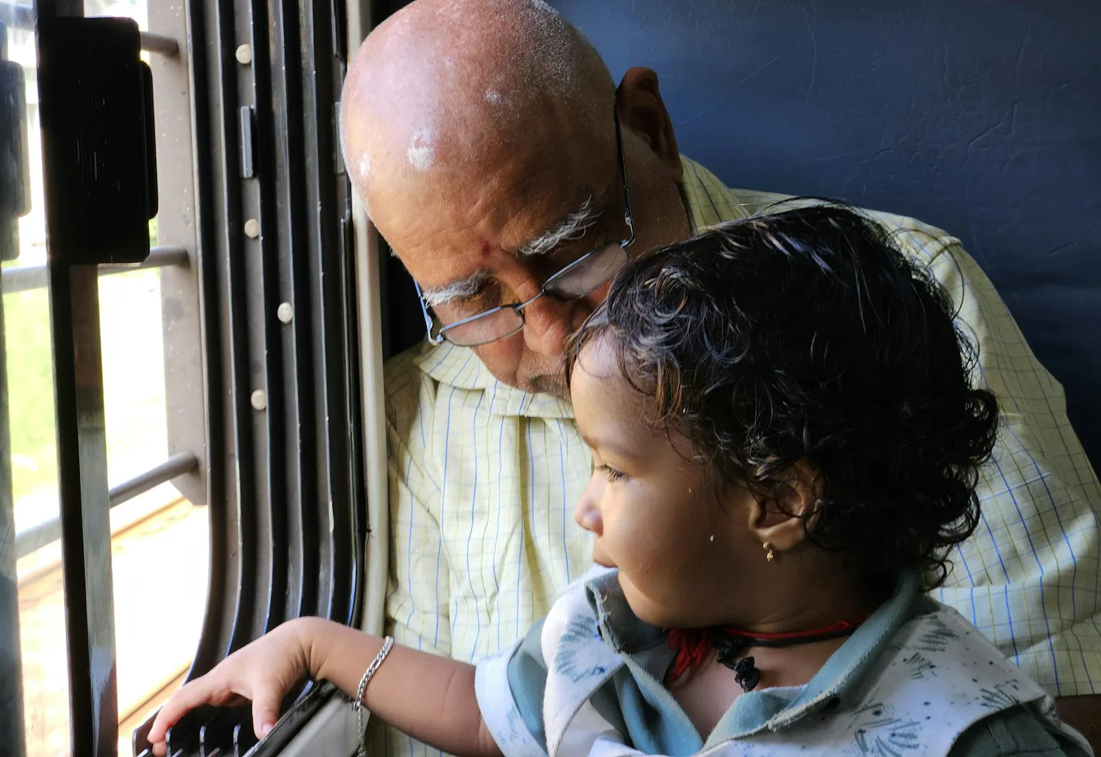 A grandparent and child sharing a quiet moment by a window